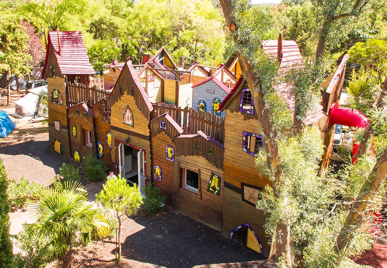 Grote houten speelstructuur met glijbaan op camping CAPFUN Fumades in ALLEGRE-LES-FUMADES.