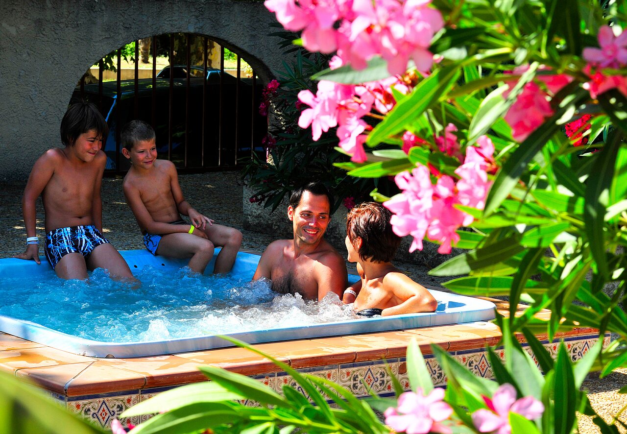 Lachende familie genietend van jacuzzi op camping CAPFUN Fumades in ALLEGRE-LES-FUMADES (30).