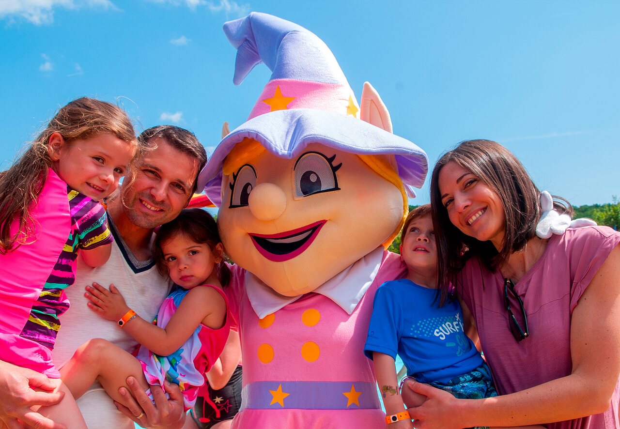 Lachende familie met de mascotte van camping CAPFUN Fumades in ALLEGRE-LES-FUMADES (30).