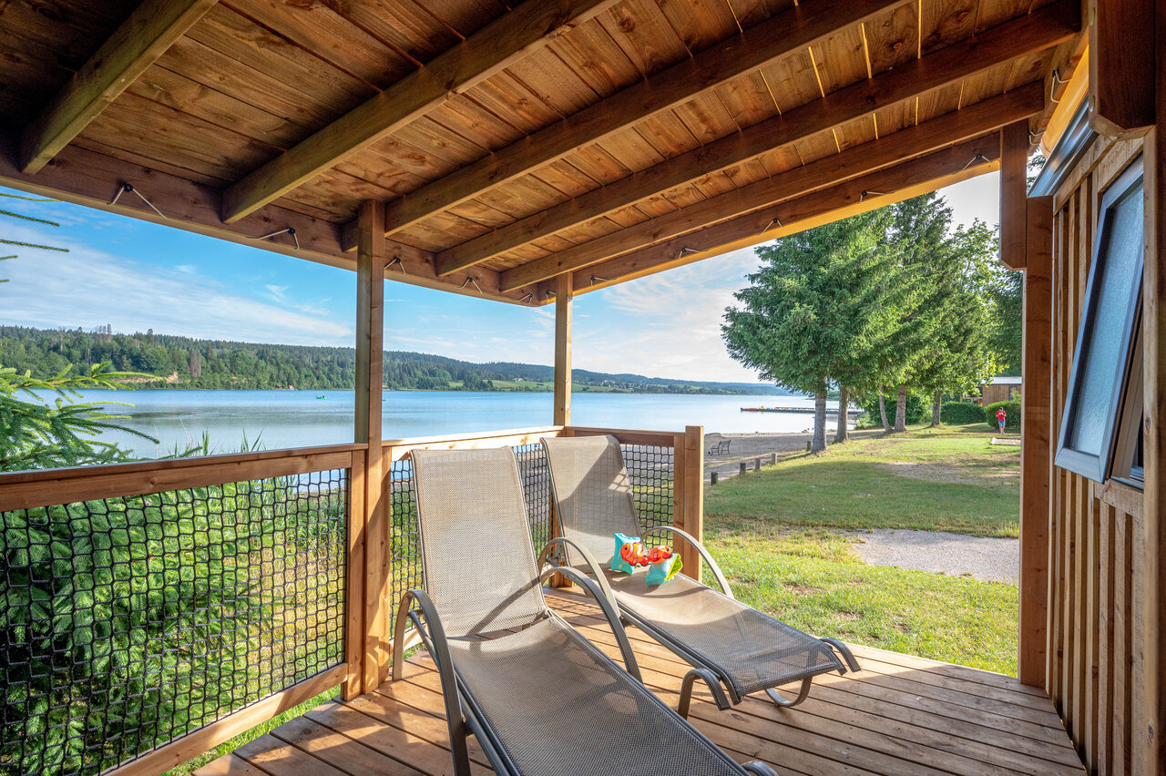 Accommodatieterras met ligstoelen en uitzicht op het meer op camping CAPFUN Fuvettes in Malbuisson (25).