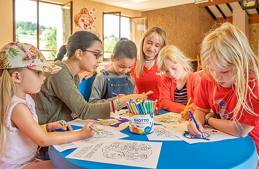 Kinderen kleuren met animator tijdens activiteit op camping CAPFUN Fuvettes in Malbuisson.