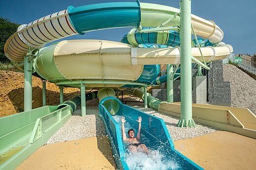 Reusachtige waterglijbanen met een vakantieganger die glijdt op camping CAPFUN Fuvettes in Malbuisson (25).