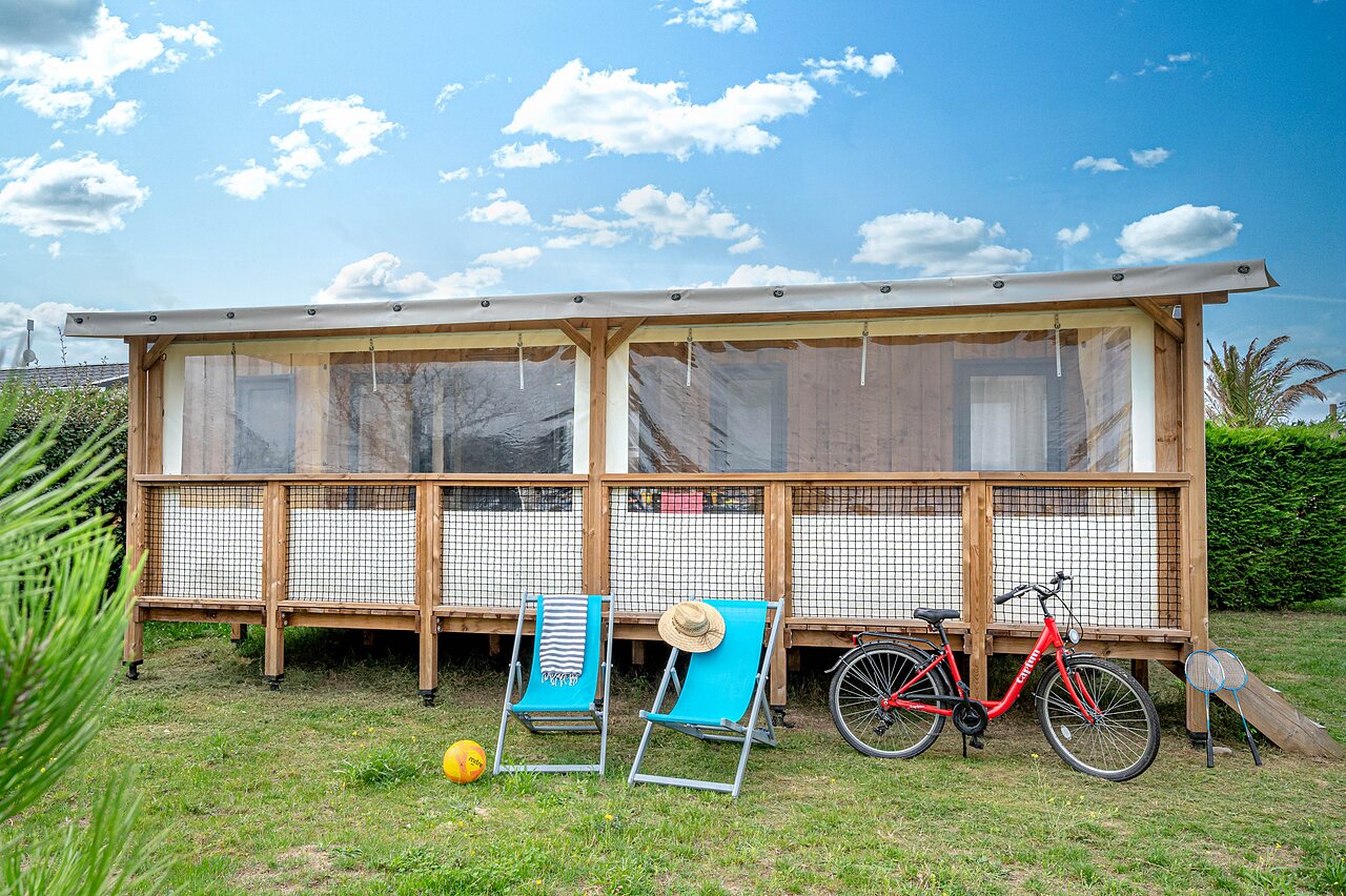 Glamping lodge, ligstoelen, fiets op camping CAPFUN Golf in SAINT JEAN DE LA RIVIERE (50).