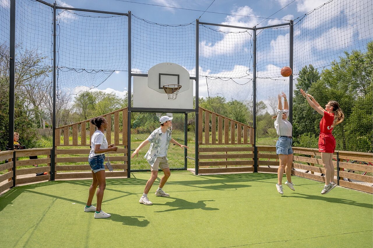 Multisportterrein met jongeren die basketballen op camping CAPFUN Golf in SAINT JEAN DE LA RIVIERE (50).
