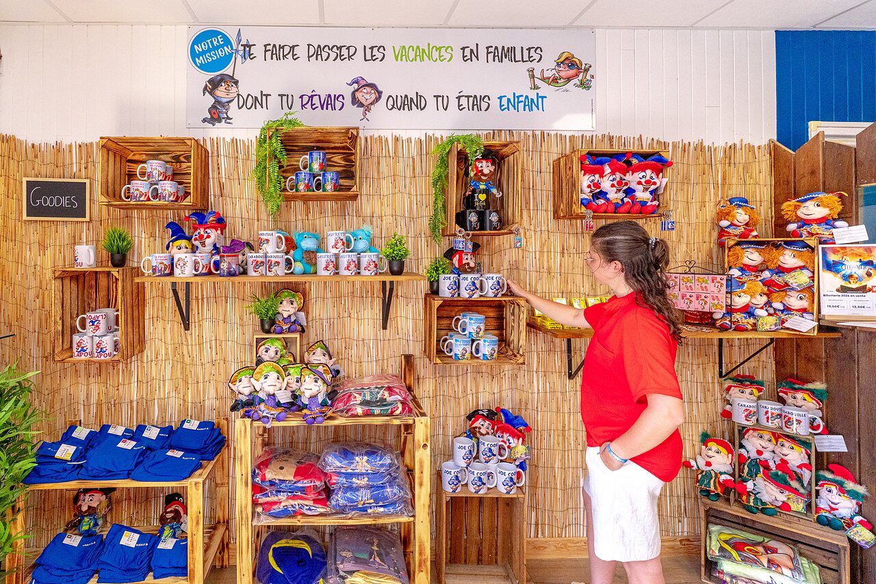 Souvenirwinkel met mokken, knuffels en textiel op camping CAPFUN Golf in SAINT JEAN DE LA RIVIERE.