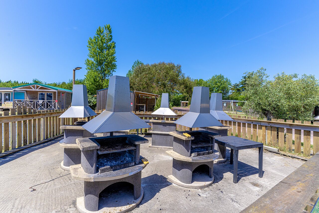 Gemeenschappelijke barbecueplaats met meerdere grills op camping CAPFUN Golf in SAINT JEAN DE LA RIVIERE (50).