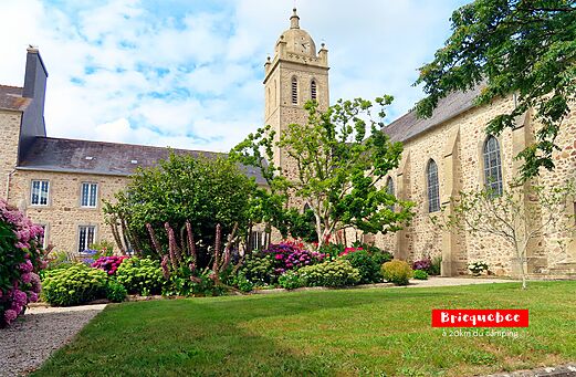 Historische kerk van Bricquebec met klokkentoren en bloementuin in Normandi�.