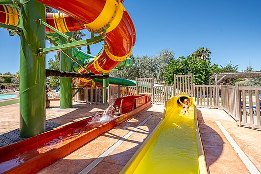 Kleurrijke waterglijbanen en kinderen die plezier hebben op camping CAPFUN Grande Cosse in Saint Pierre la Mer (11).