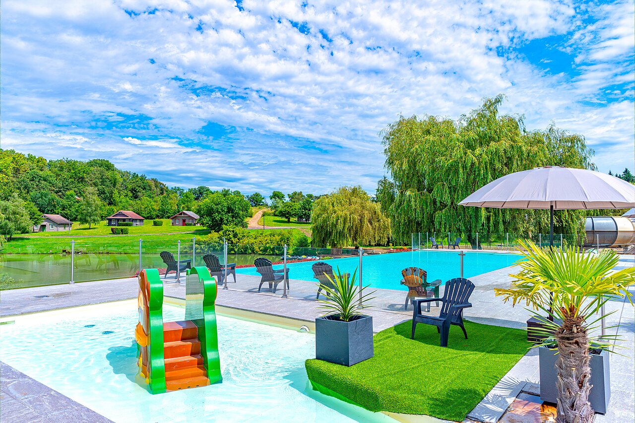 Buitenzwembad met kinderglijbaan en ligstoelen op camping CAPFUN Grand Cerf in Gimouille (58).