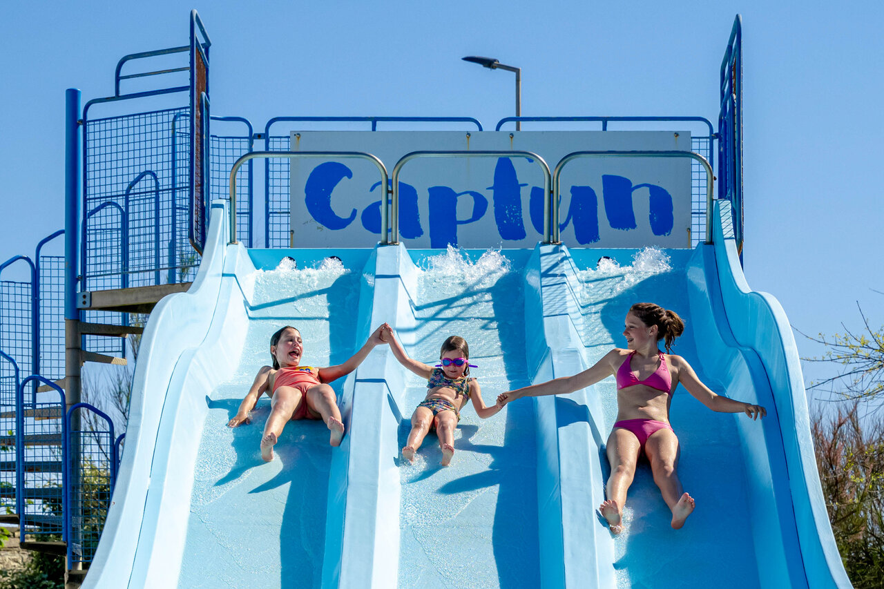 Kinderen glijden van waterglijbaan op camping CAPFUN Grand Large in FOUESNANT (29).