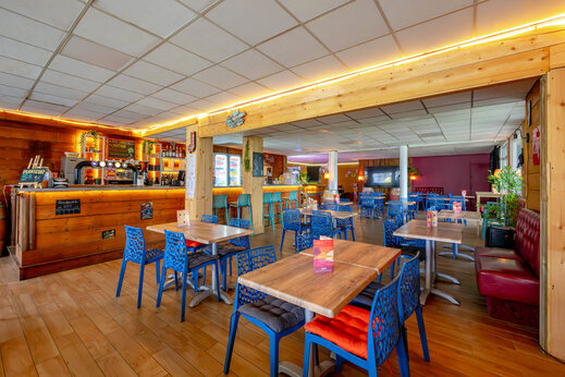 Bar en restaurant met tafels op camping CAPFUN Grand Large in FOUESNANT (29).