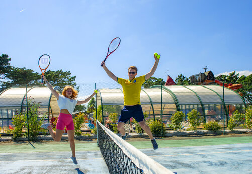 Tennisbaan en springende spelers op camping CAPFUN Grand Large in FOUESNANT (29).