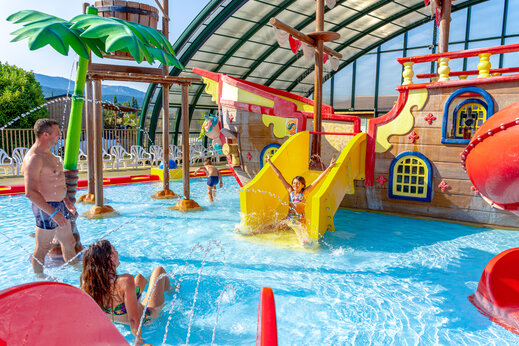 Overdekt waterpark met piratenschip, glijbanen en waterspellen op camping CAPFUN Grand Lierne in CHATEAUDOUBLE (26).