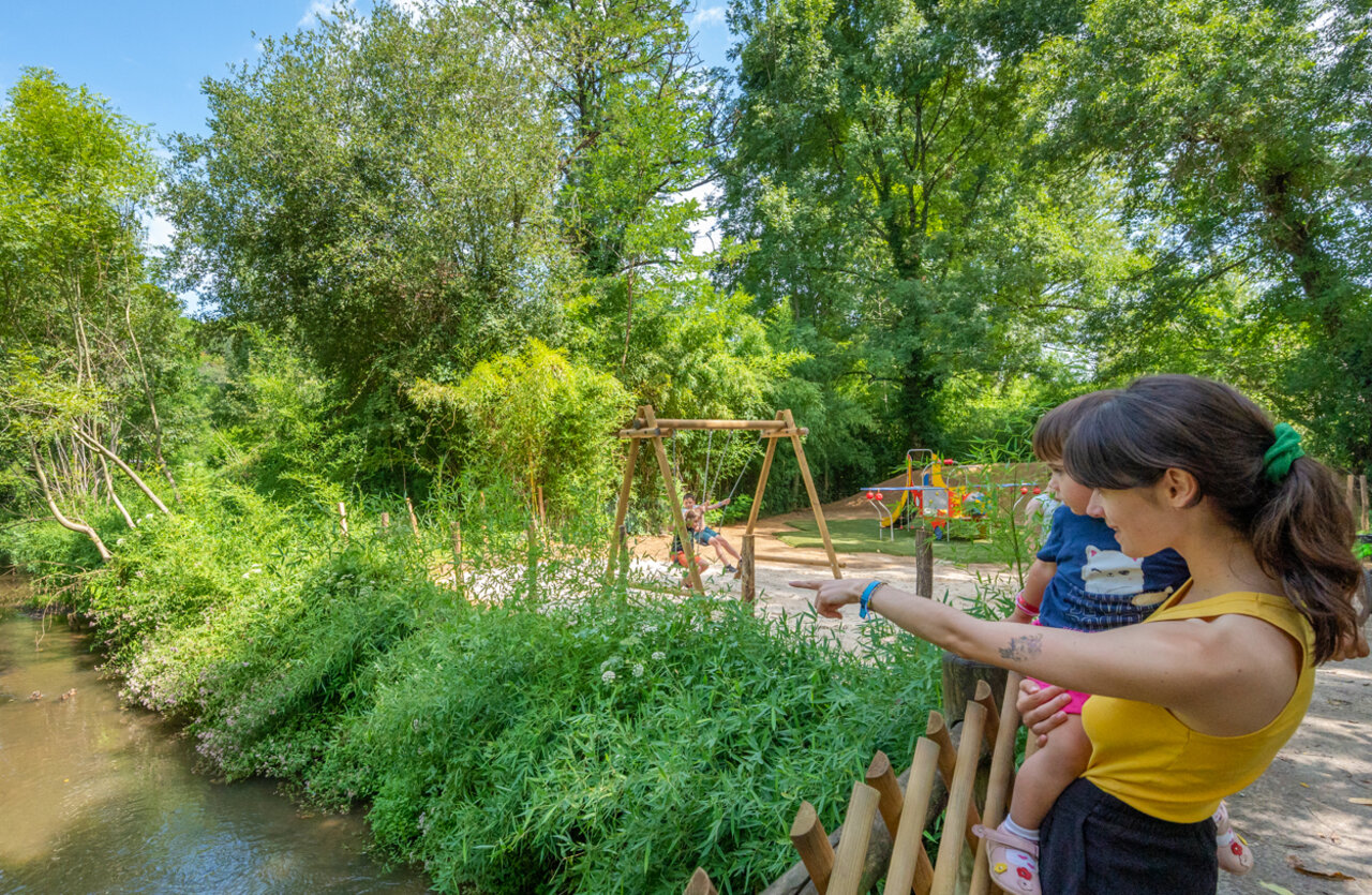 Speeltuin met schommels en kinderen, rivieroever op camping VAGUES OCEANES Granges in GROLEJAC (24).