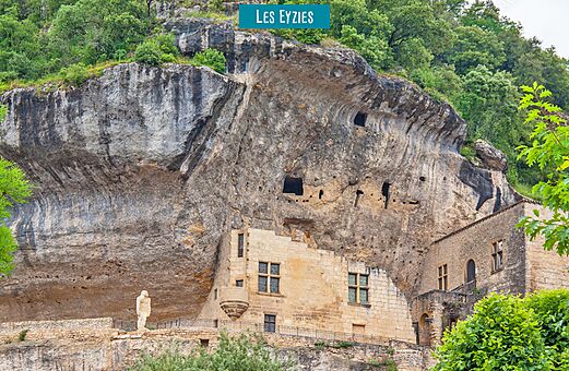 Troglodietenwoningen en prehistorisch standbeeld in Les Eyzies, Dordogne.