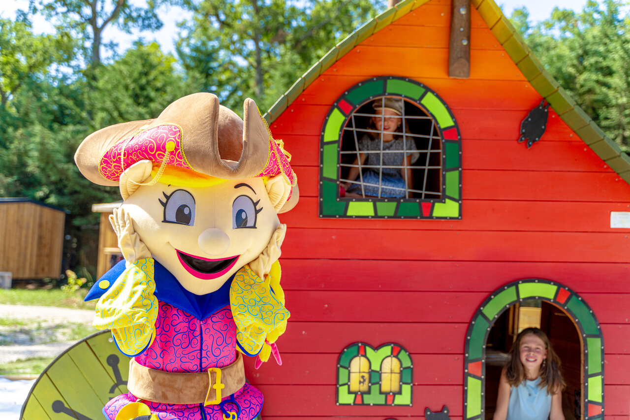 Mascotte en kinderen spelend in een kleurrijk speelhuis op camping CAPFUN Grenouill�re in Su�vres (41).