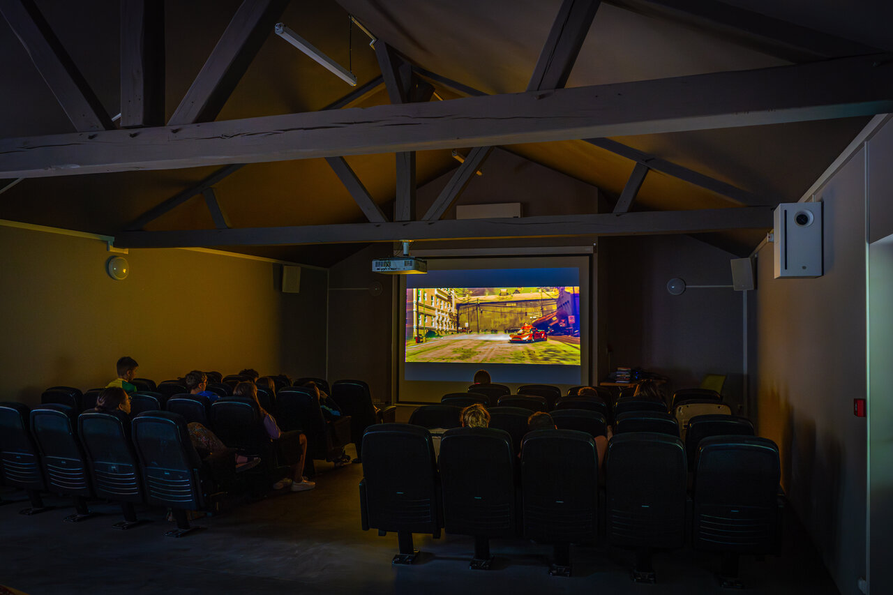 Binnencinema, groot scherm en toeschouwers op camping CAPFUN Grenouill�re in Su�vres (41).