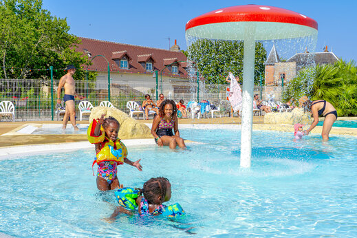 Kinderen spelen in het zwembad met sproeipaddestoel op camping CAPFUN Grenouillère in Suèvres (41).