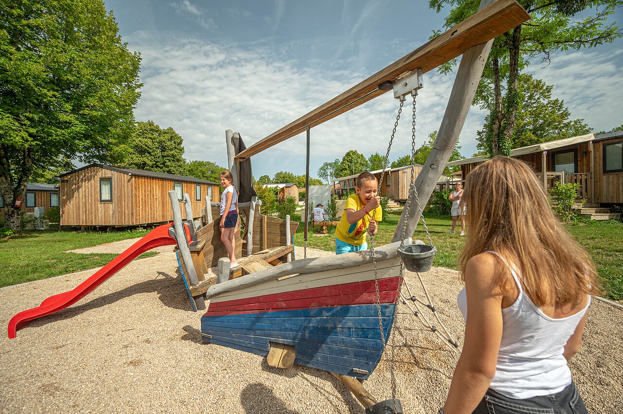 Speeltuin, boot, glijbaan en kinderen op camping CLICOCHIC Grisi�re (39).