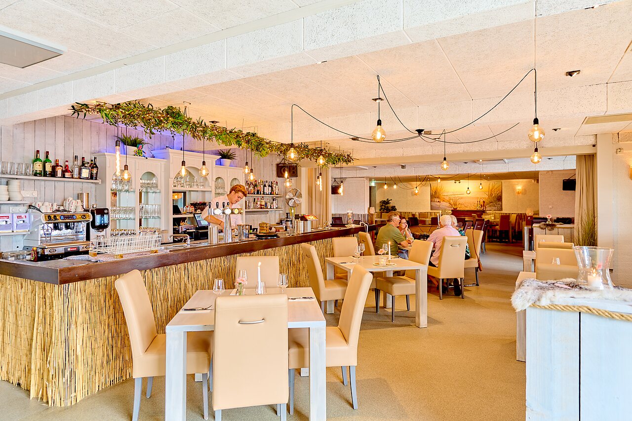 Modern restaurant en bar met tafels en bediening op camping CAPFUN Groene Eiland in Appeltern.