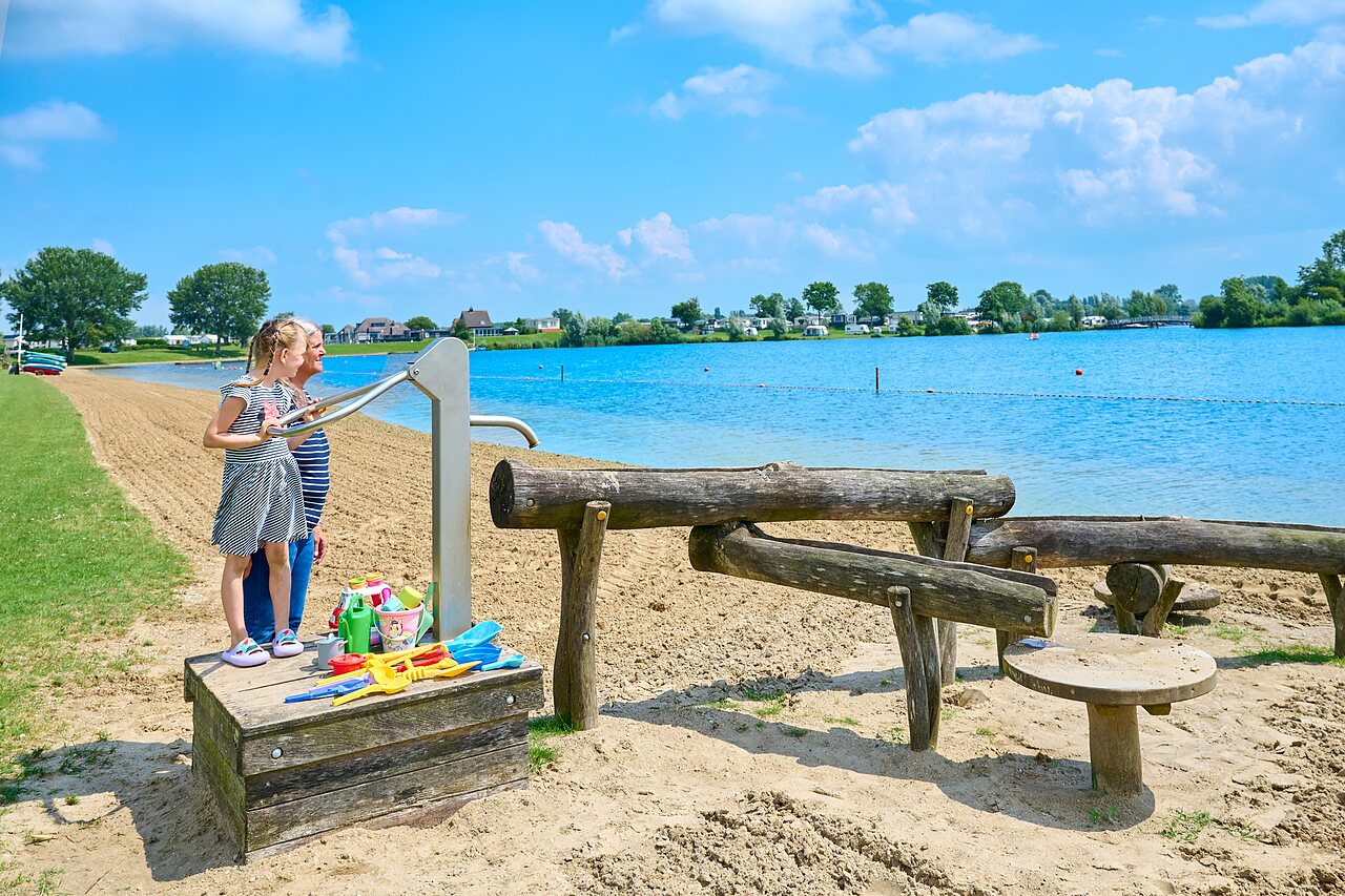 Zandstrand, waterspelen voor kinderen op camping CAPFUN Groene Eiland in Appeltern.