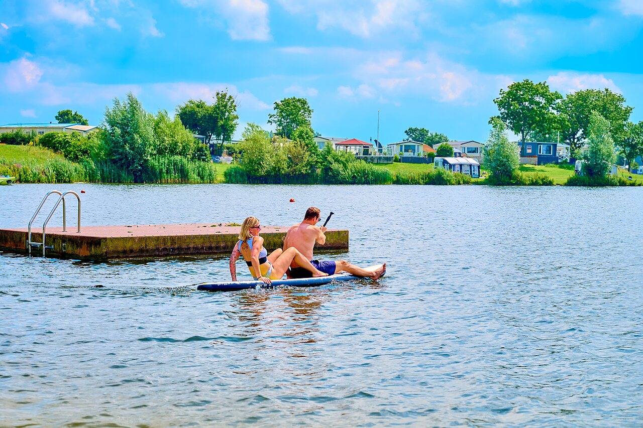 Koppel op paddleboard op het meer van camping CAPFUN Groene Eiland in Appeltern.