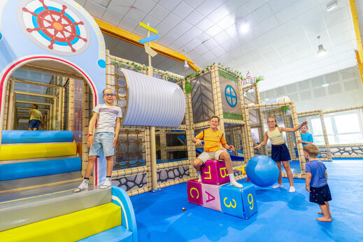 Binnenspeeltuin met speeltoestellen en kinderen op camping VAGUES OCEANES Grosses Pierres in Saint-Georges-d'Oléron (17).