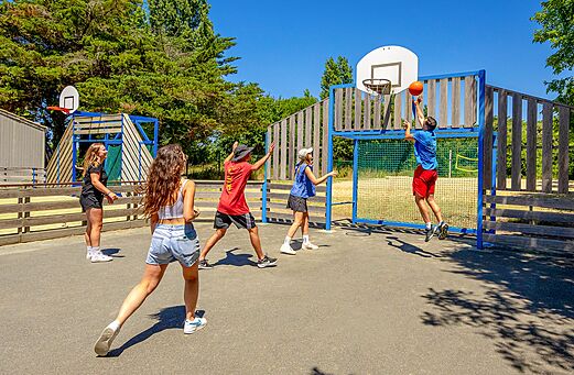 Jongeren basketballen op het multisportterrein van camping VAGUES OCEANES Grosses Pierres in Saint-Georges-d'Oléron.