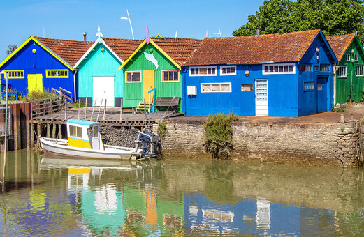 Kleurrijke oesterhutten en vissersboot in een typisch dorp in Charente-Maritime.