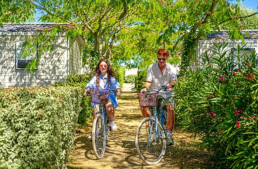 Koppel op fiets op groen pad bij camping VAGUES OCEANES Grosses Pierres.