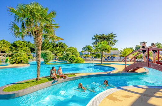 Buitenzwembad, rivier en brug op camping VAGUES OCEANES Grosses Pierres.