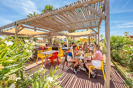Levendig buitenrestaurantterras met gasten op camping VAGUES OCEANES Hamacs in Fleury (11).