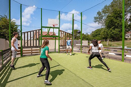 Jongeren basketballen op multisportterrein bij camping CLICOCHIC Haras de Deauville.