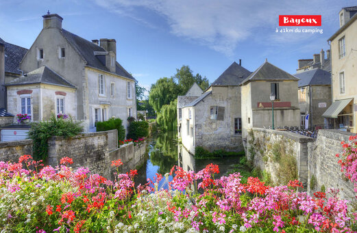 Historische stad Bayeux met bloemrijke gracht en oude huizen in Normandië.
