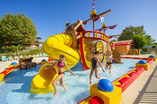 Speelzwembad met glijbaan en piratenschip op camping CAPFUN Hauts de Ratebout in STE FOY DE BELVES (24).