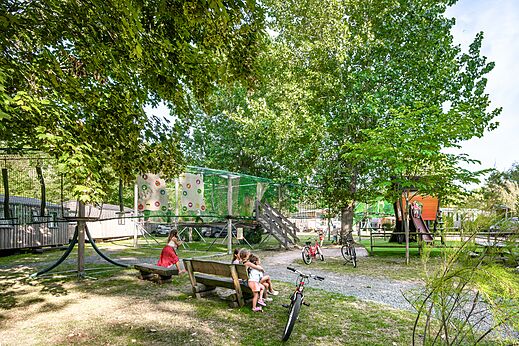 Speeltuin met klimnet, boomhutglijbaan en kinderen op camping CLICOCHIC Havre de Bernières in Bernières-sur-Mer (14).