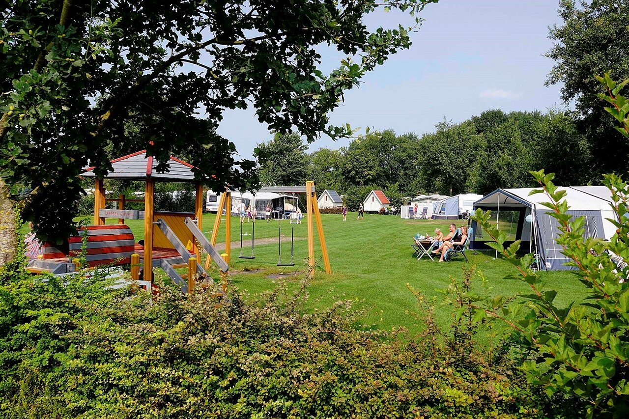 Speeltuin met schommels en glijbaan, kampeerplaatsen op camping CAPFUN Heino.
