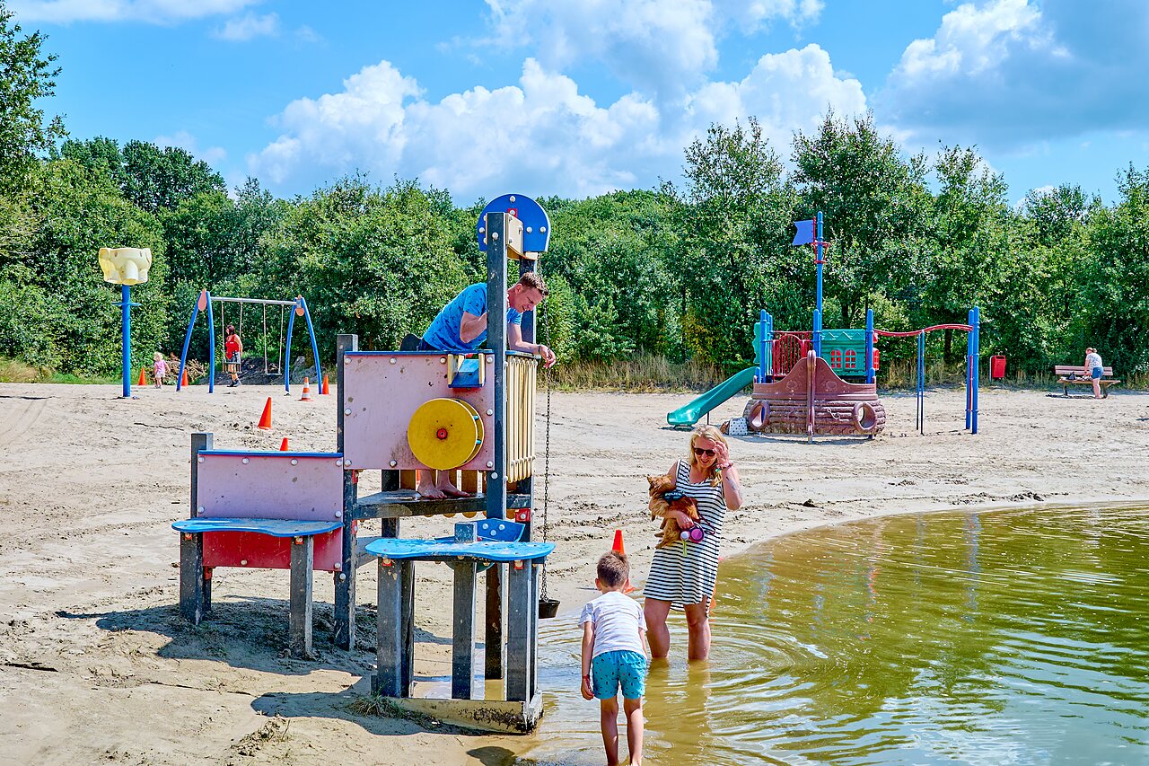 Waterspeeltuin en zandstrand met speeltoestellen op camping CAPFUN Heino in Heino.