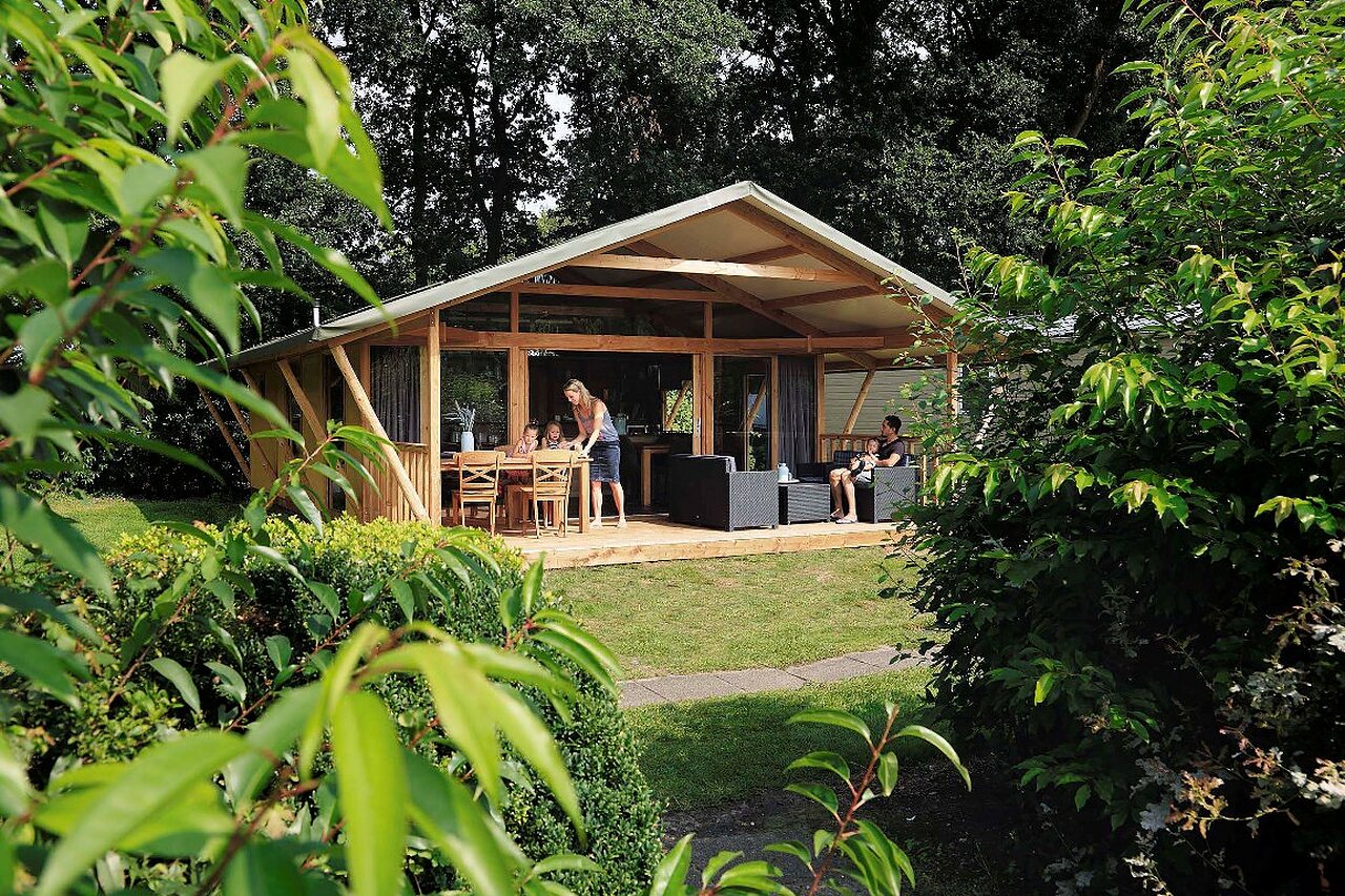 Familie lodgetent met groen terras op camping CAPFUN Heino in Heino.