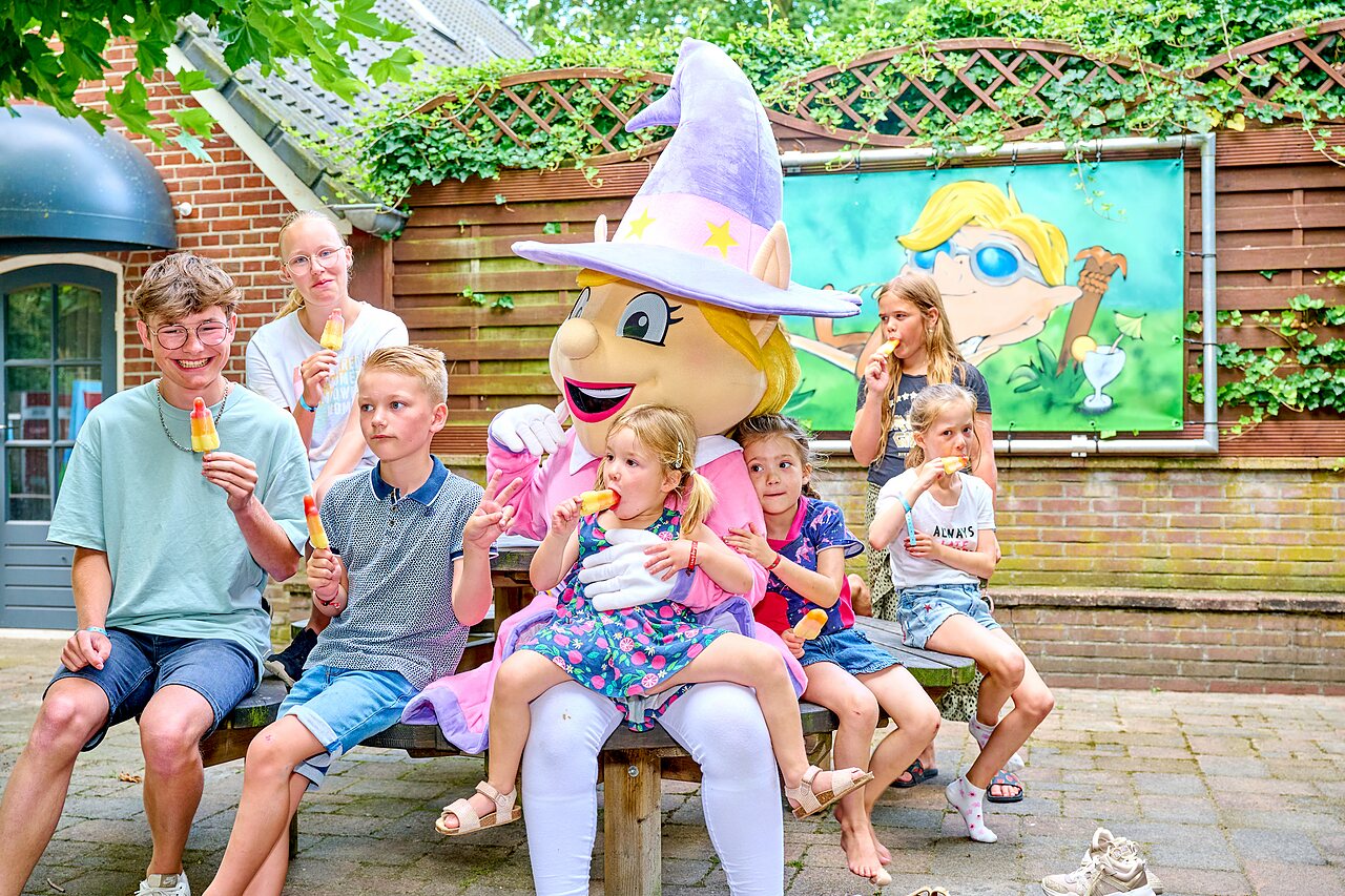 Mascotte en lachende kinderen eten ijsjes op camping CAPFUN Heino in Heino.