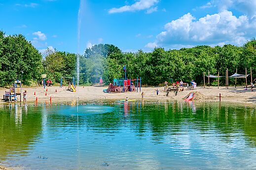 Zandstrand met speeltuinen en natuurlijke zwemvijver op camping CAPFUN Heino in Heino.