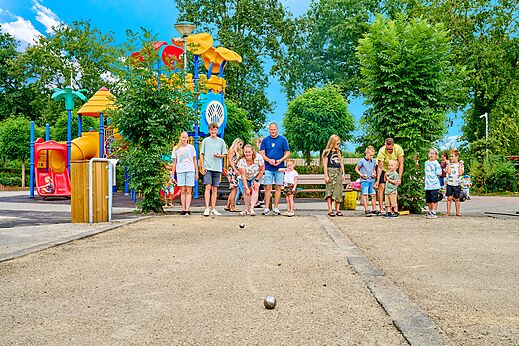Familie speelt jeu de boules bij een speeltuin op camping CAPFUN Heino in Heino.