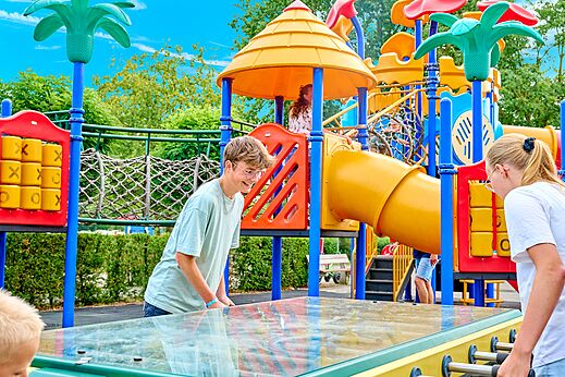 Kleurrijke speeltuin met glijbanen en tafelvoetbal op camping CAPFUN Heino in Heino.