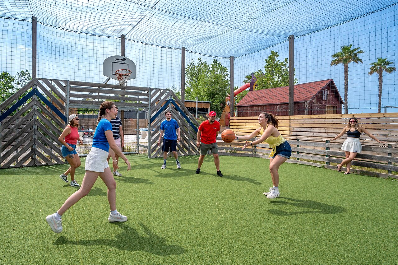 Multisportterrein met jongeren die basketballen op camping CAPFUN Hermitage in SERIGNAN (34).