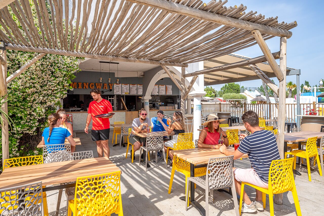 Buiten restaurantterras met gasten en ober op CAPFUN Hermitage, SERIGNAN (34).