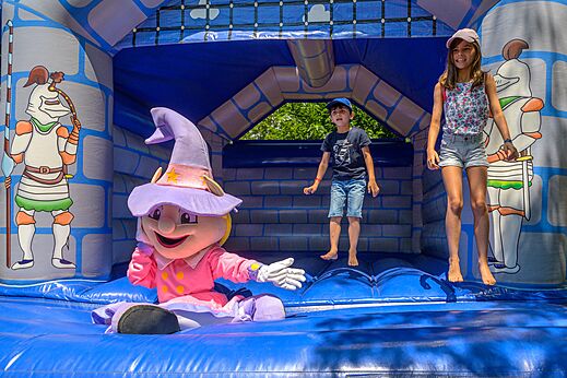 Opblaasbaar kasteel met kinderen en mascotte op camping CAPFUN Hermitage in SERIGNAN (34).