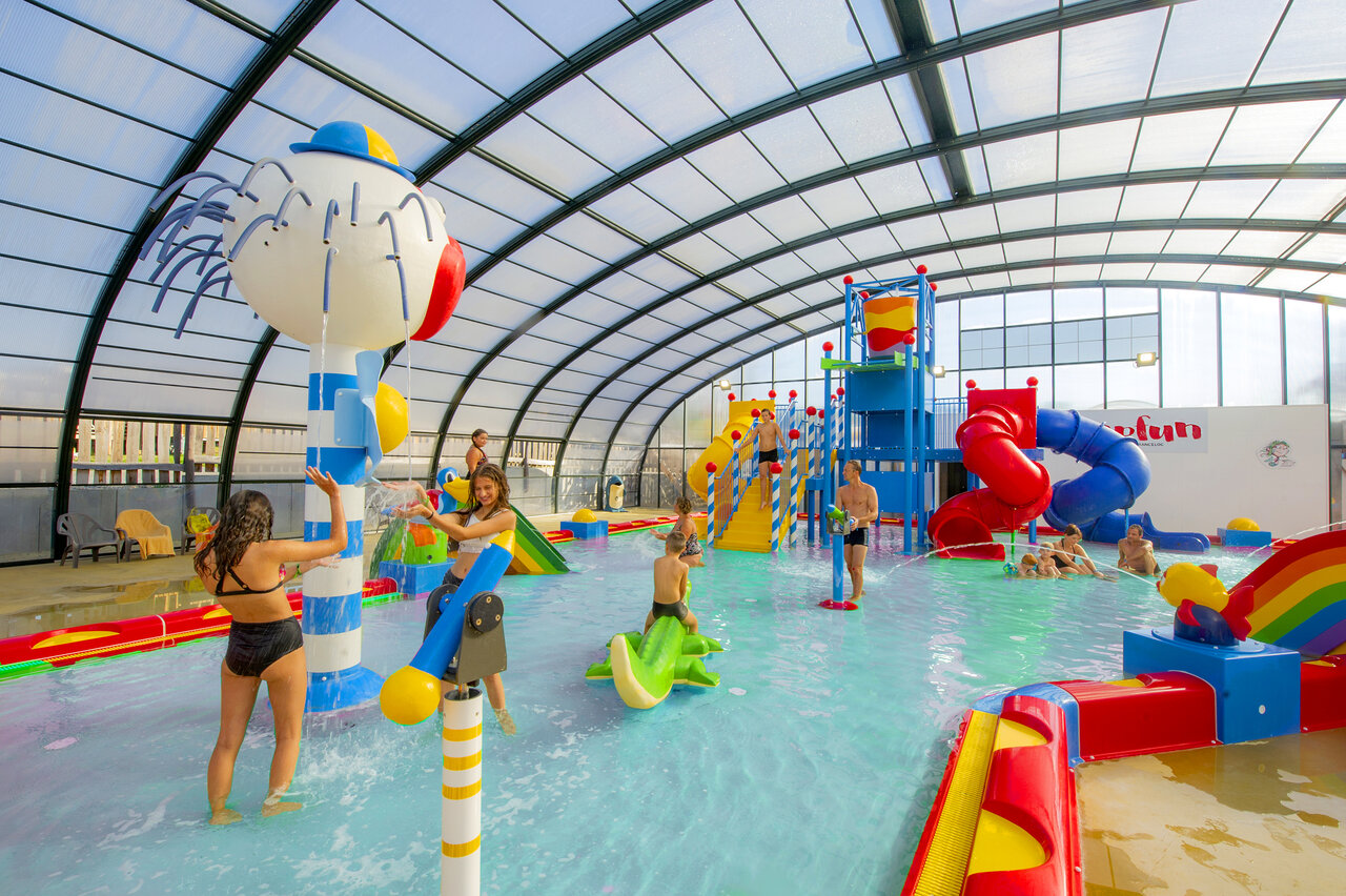 Overdekt waterpark met glijbanen en waterspelen op camping CAPFUN Hirondelle in Oteppe.