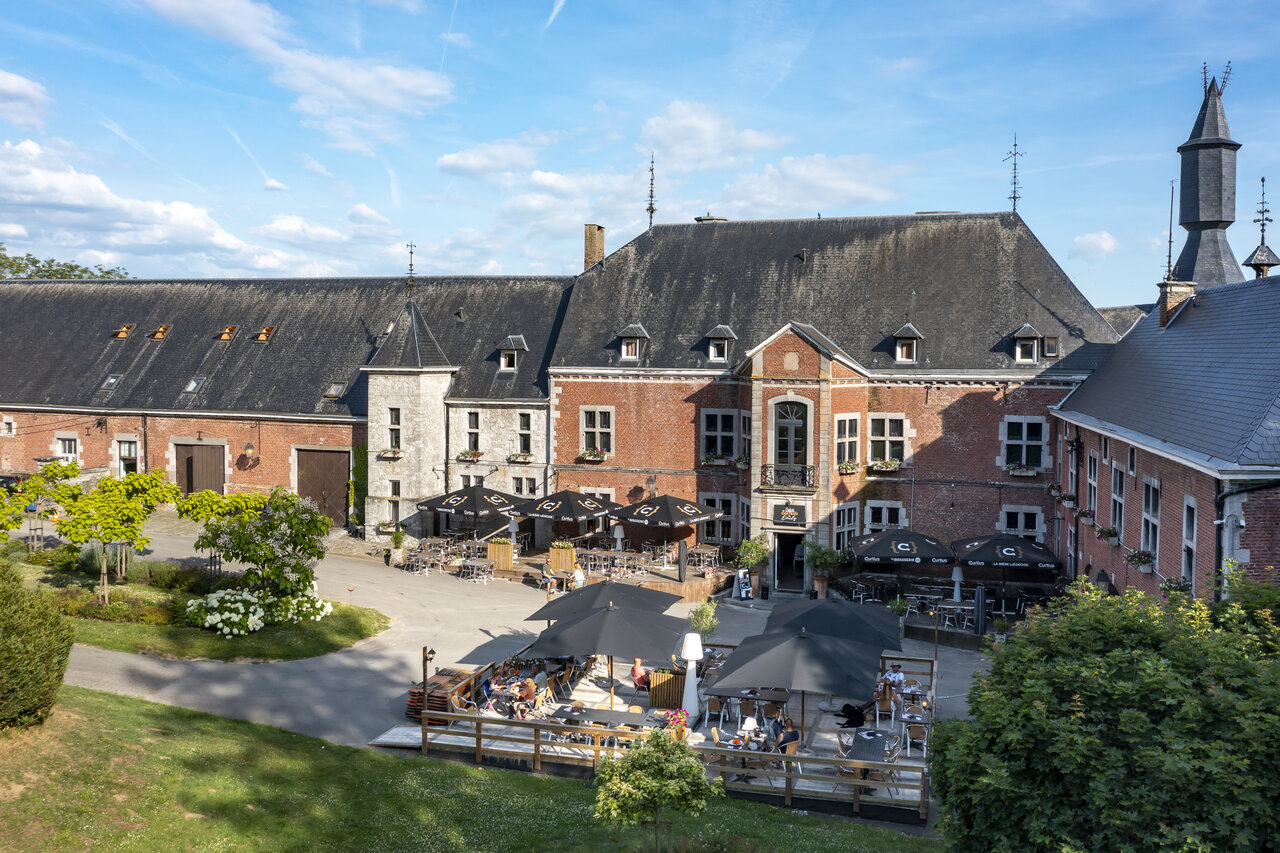 Historisch gebouw, restaurant- en barterras op camping CAPFUN Hirondelle, Oteppe.