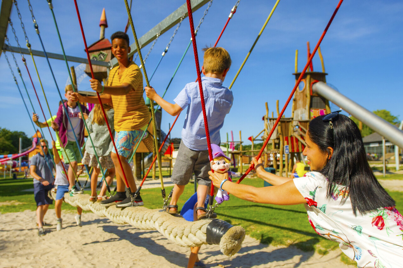 Speeltuin met touwbrug en kinderen op camping CAPFUN Hirondelle in Oteppe.