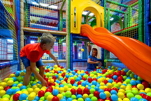 Kinderen spelen in kleurrijke ballenbak met glijbaan op camping CAPFUN Hirondelle in Oteppe.